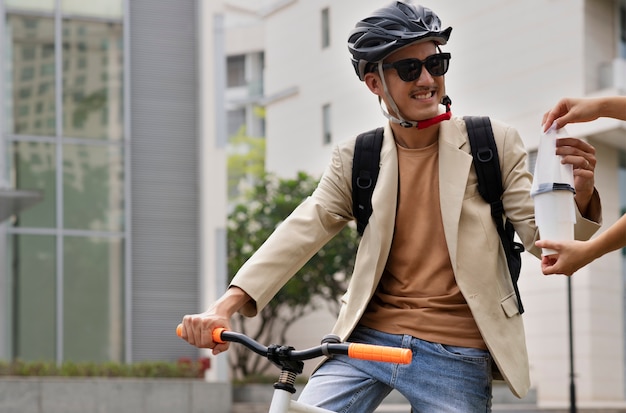 Foto gratuita hombre sonriente de tiro medio yendo a trabajar en bicicleta