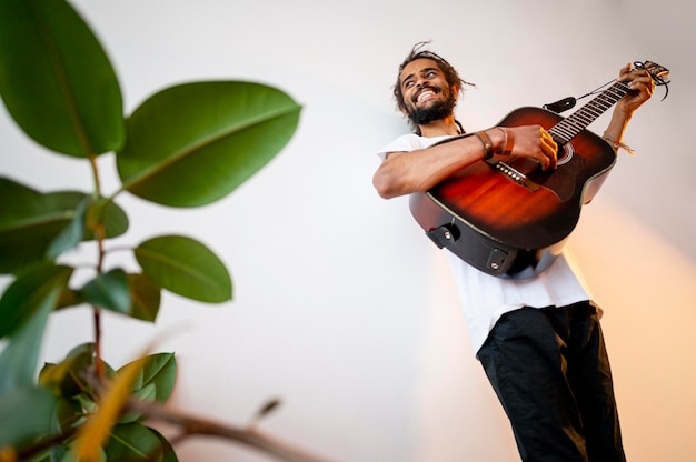 Foto gratuita hombre sonriente tocando la guitarra con espacio de copia