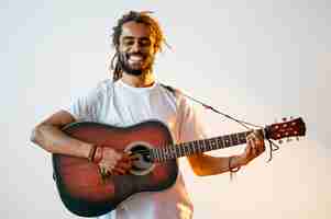 Foto gratuita hombre sonriente tocando la guitarra