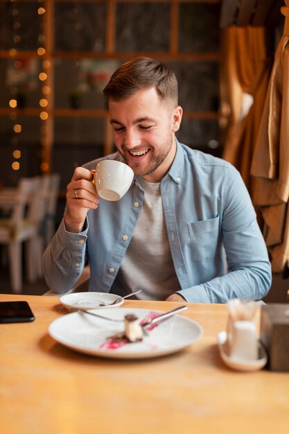 Hombre sonriente tomando café