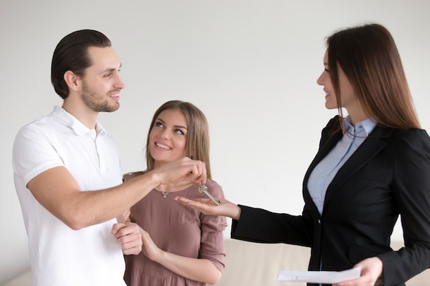 Hombre sonriente tomando las llaves del apartamento, nuevo hogar para pareja