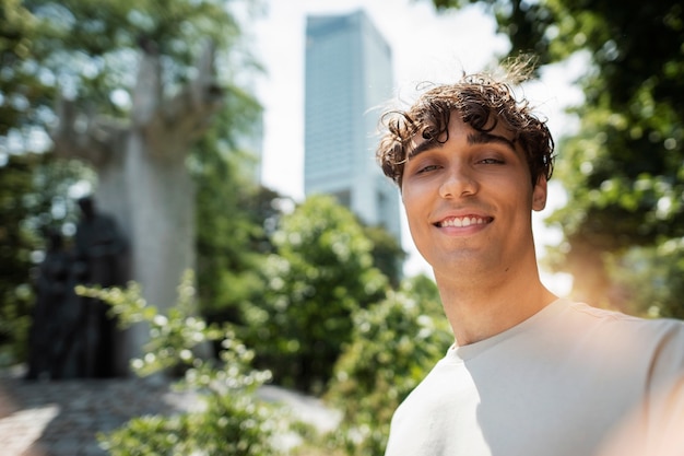 Hombre sonriente tomando selfie en la naturaleza tiro medio