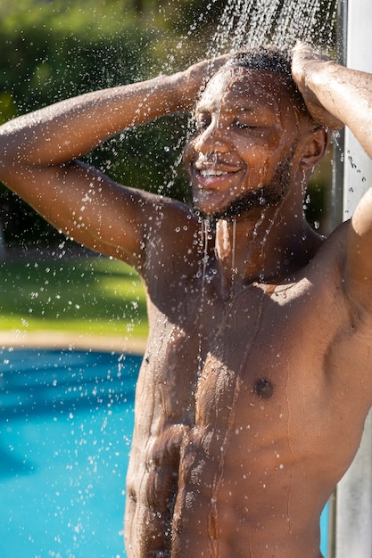 Foto gratuita hombre sonriente tomando vista lateral de la ducha