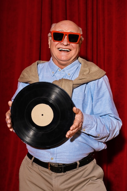 Hombre sonriente con vista frontal de disco de vinilo