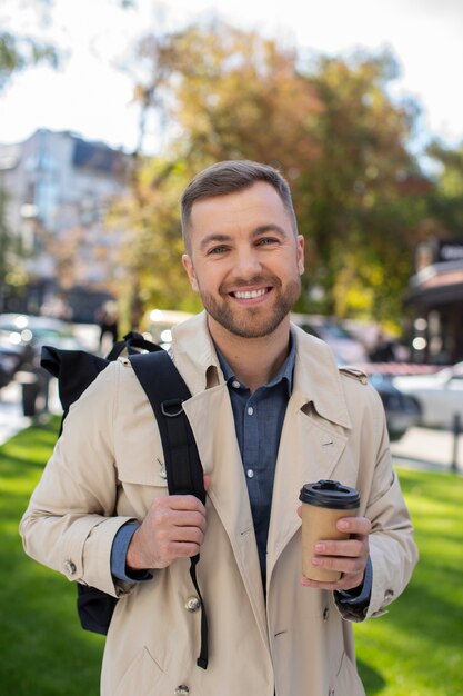 Hombre sonriente con vista frontal de la taza de café