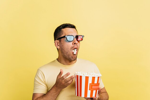 Hombre sorprendido comiendo palomitas de maíz con espacio de copia