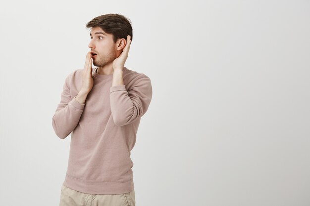 Hombre sorprendido escucha una conversación interesante, escuchando a escondidas