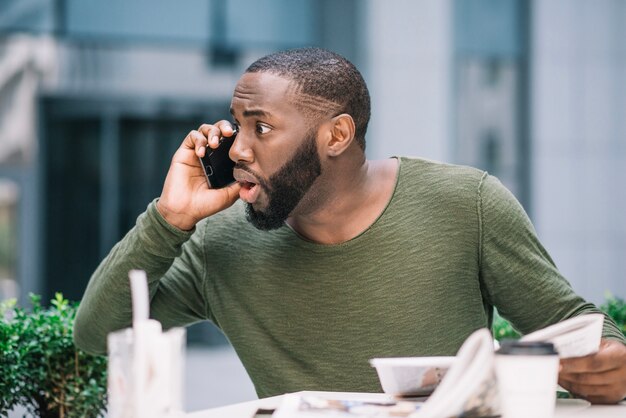 Hombre sorprendido hablando por teléfono