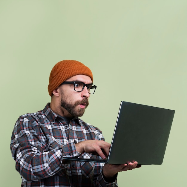 Hombre sorprendido mirando portátil