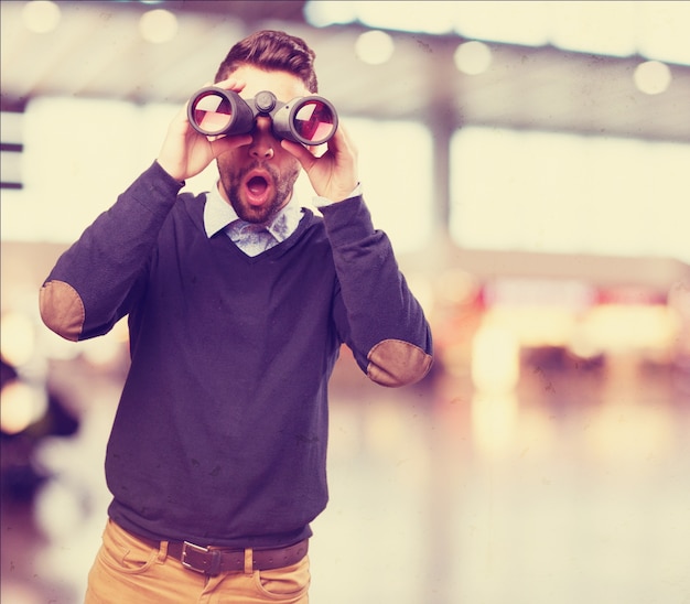 Foto gratuita hombre sorprendido mirando por unos prismáticos