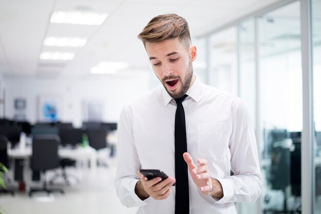 Hombre sorprendido mirando su teléfono