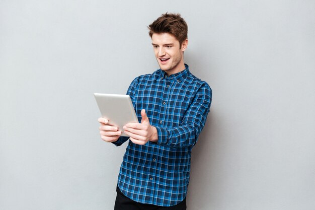 Hombre sorprendido mirando tablet PC aislado