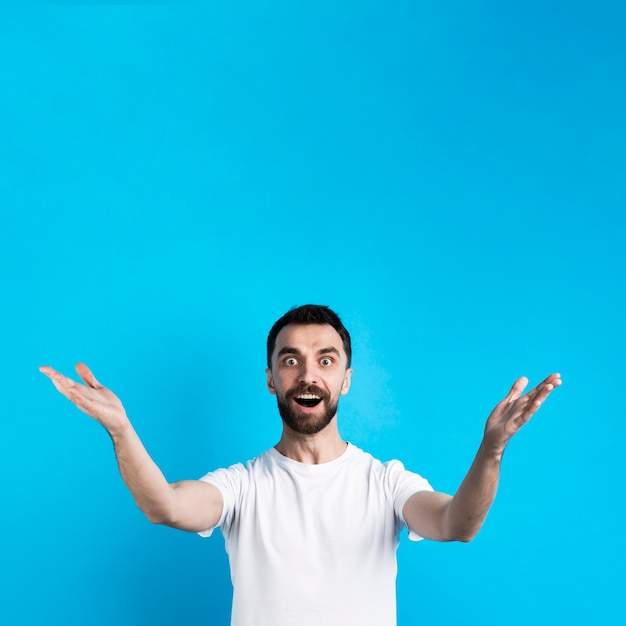 Hombre sorprendido posando con los brazos abiertos