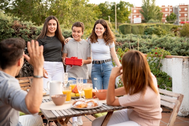 Hombre sorprendido con regalo en reunión familiar