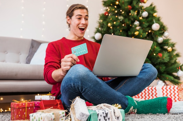 Foto gratuita hombre sorprendido con tarjeta de crédito y portátil