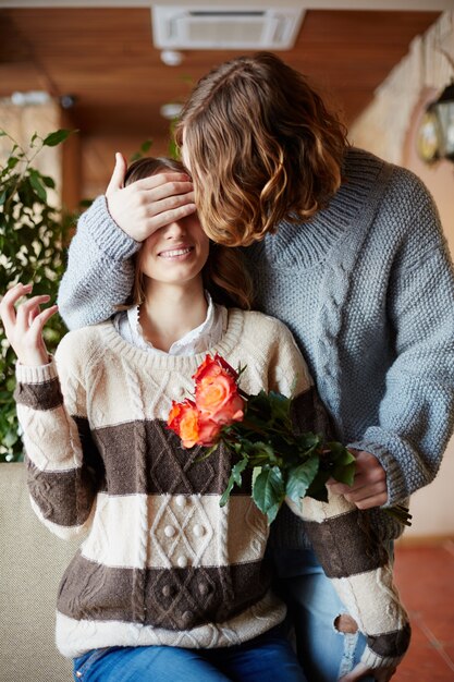 Hombre sorprendiendo a su esposa con flores