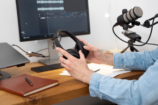 Hombre sosteniendo auriculares y preparándose para el podcast