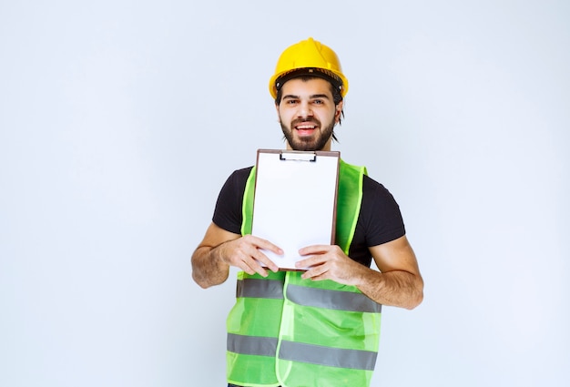 Foto gratuita hombre sosteniendo y demostrando la versión final del proyecto de construcción.