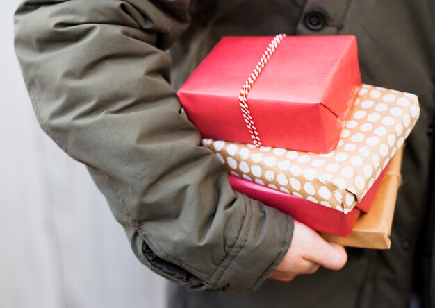 Hombre sosteniendo el montón de cajas presentes