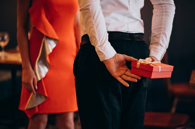 Hombre sosteniendo un regalo para su novia en el día de San Valentín