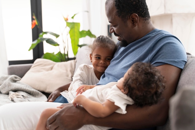 Foto gratuita hombre sosteniendo a sus hijas en sus brazos