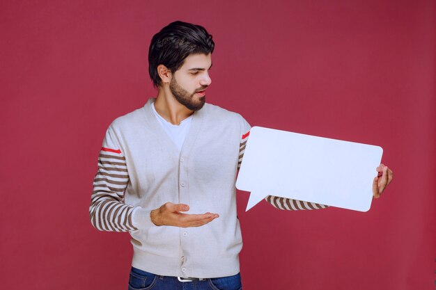 Hombre sosteniendo un tablero de ideas en blanco y haciendo presentación.