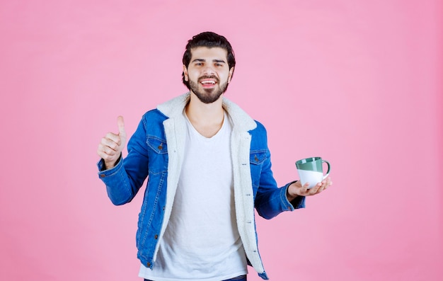 Hombre sosteniendo una taza de café y disfrutando del sabor.