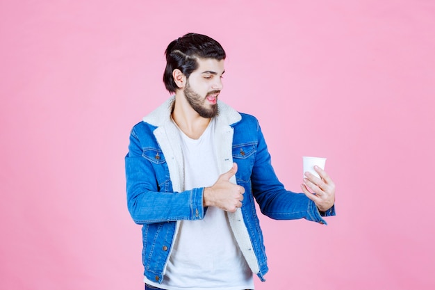 Hombre sosteniendo una taza de café y disfrutando del sabor