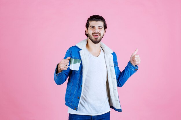 Hombre sosteniendo una taza de café y disfrutó del sabor