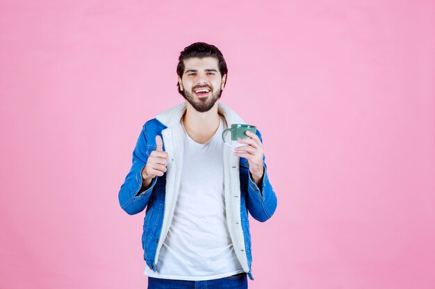 Hombre sosteniendo una taza de café y disfrutó del sabor