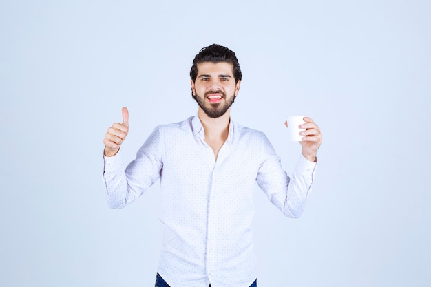 Hombre sosteniendo una taza de café y disfrutó del sabor