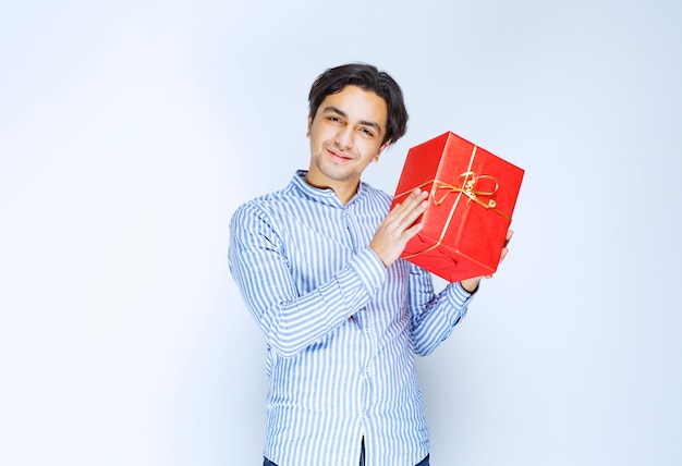 Hombre sosteniendo u ofreciendo una caja de regalo roja a su novia. Foto de alta calidad