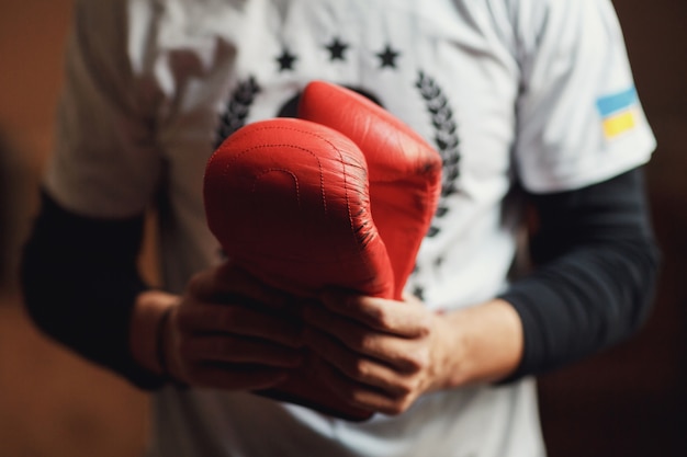 El hombre sostiene guantes de boxeo en sus manos