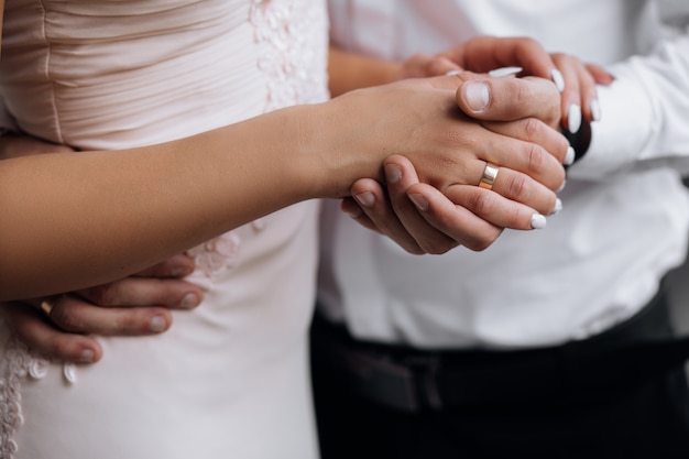 El hombre sostiene la mano de la mujer tierna en su brazo fuerte.