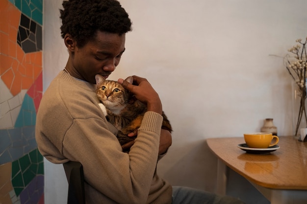 Foto gratuita hombre con su adorable gato mascota