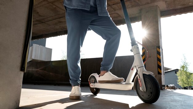 Hombre con su scooter en un estacionamiento en el interior