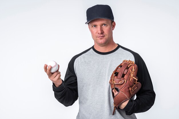 Hombre sujetando béisbol y guante