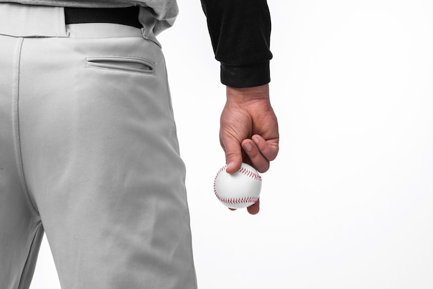 Hombre sujetando el béisbol con vista posterior