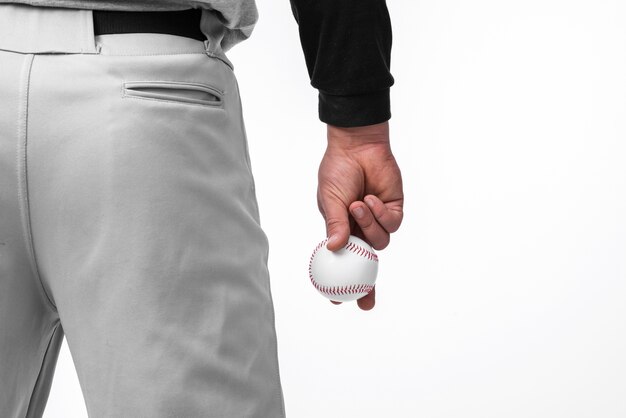 Hombre sujetando el béisbol con vista posterior