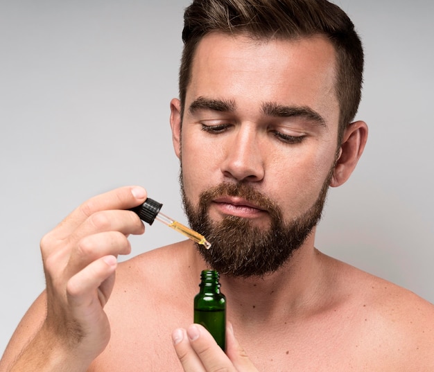 Hombre sujetando una botella de aceite de cara de cerca