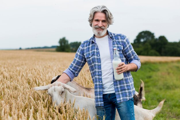 Hombre sujetando una botella de leche de cabra