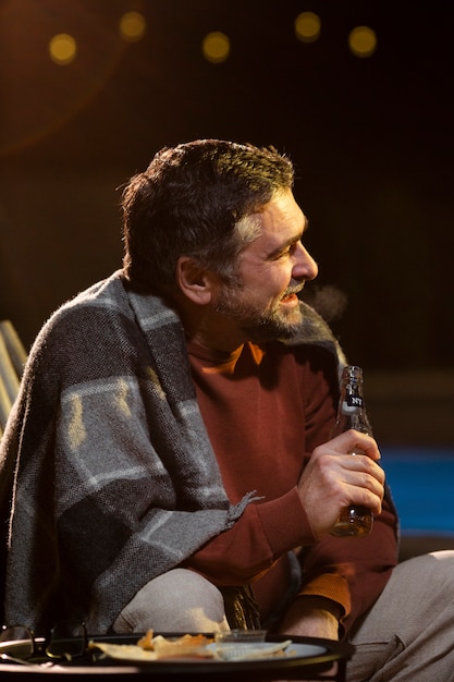 Foto gratuita hombre sujetando una botella de tiro medio