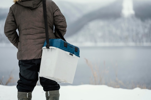 Foto gratuita hombre sujetando una caja para el pescado que atrapó