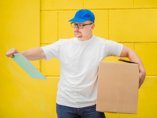 Foto gratuita hombre sujetando caja y portapapeles