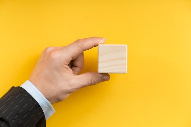 Hombre sujetando un cubo de madera en blanco