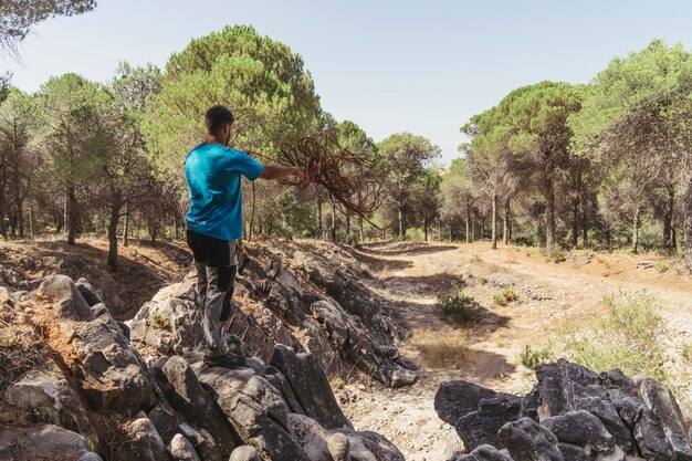 Hombre sujetando cuerda en bosque