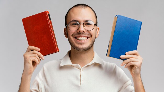 Hombre sujetando dos libros y riendo