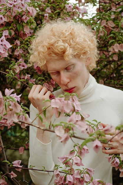 Foto gratuita hombre sujetando flores rosas posando en el parque