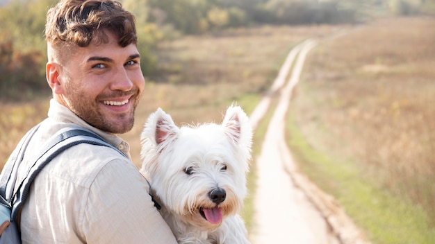 Foto gratuita hombre sujetando lindo perro tiro medio