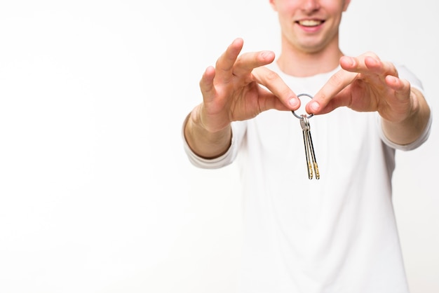Hombre sujetando llaves con copyspace